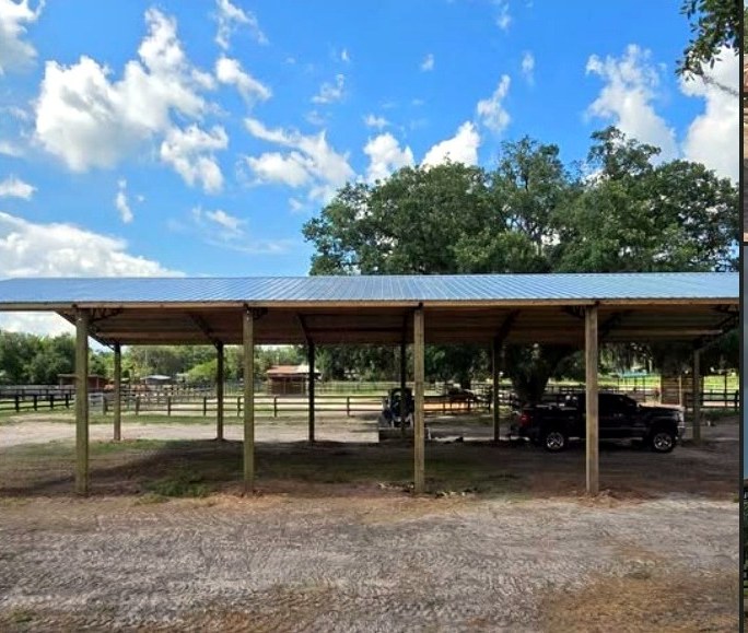 Wide open-sided metal-roof carport on a rural property