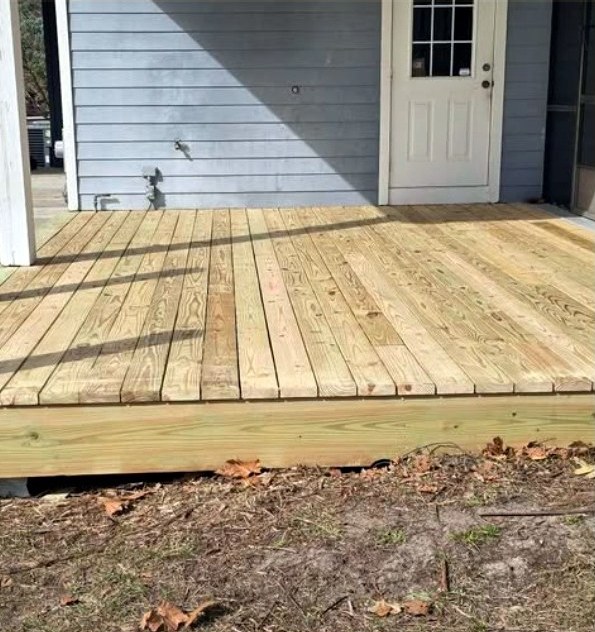 Newly rebuilt wooden deck beside a home