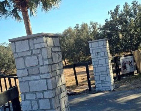 Stone column construction detail beside a metal gate